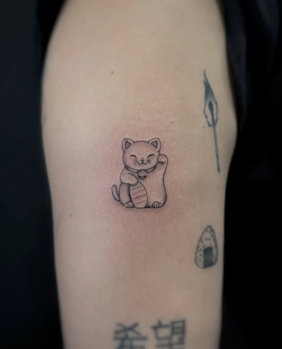 Kleine Winkekatze am Oberarm — Fine Line Tattoo von Alexander