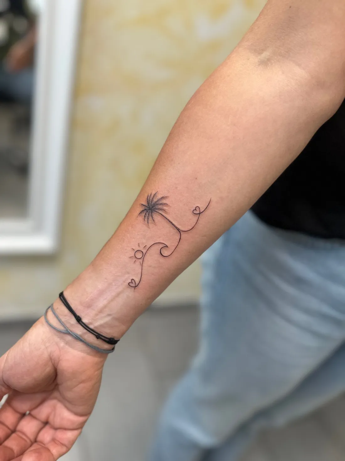 Palme, Welle und Sonne am Handgelenk — Fine Line Tattoo von Marko