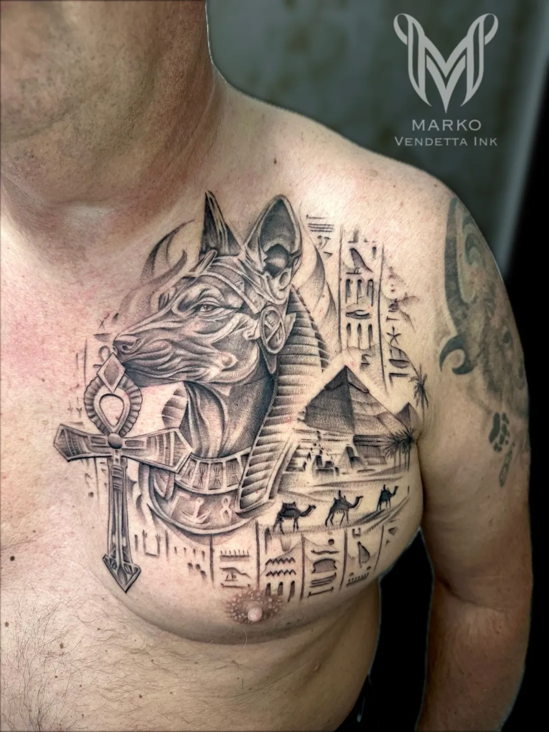 Anubis mit Pyramiden und Hieroglyphen auf Brust — Realismus Tattoo von Marko